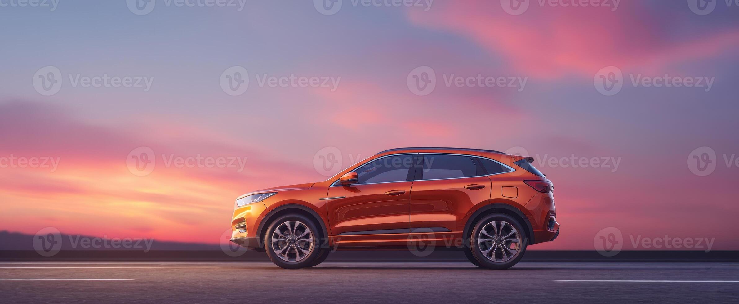 The modern orange SUV against a stunning sunset backdrop on a tranquil road photo