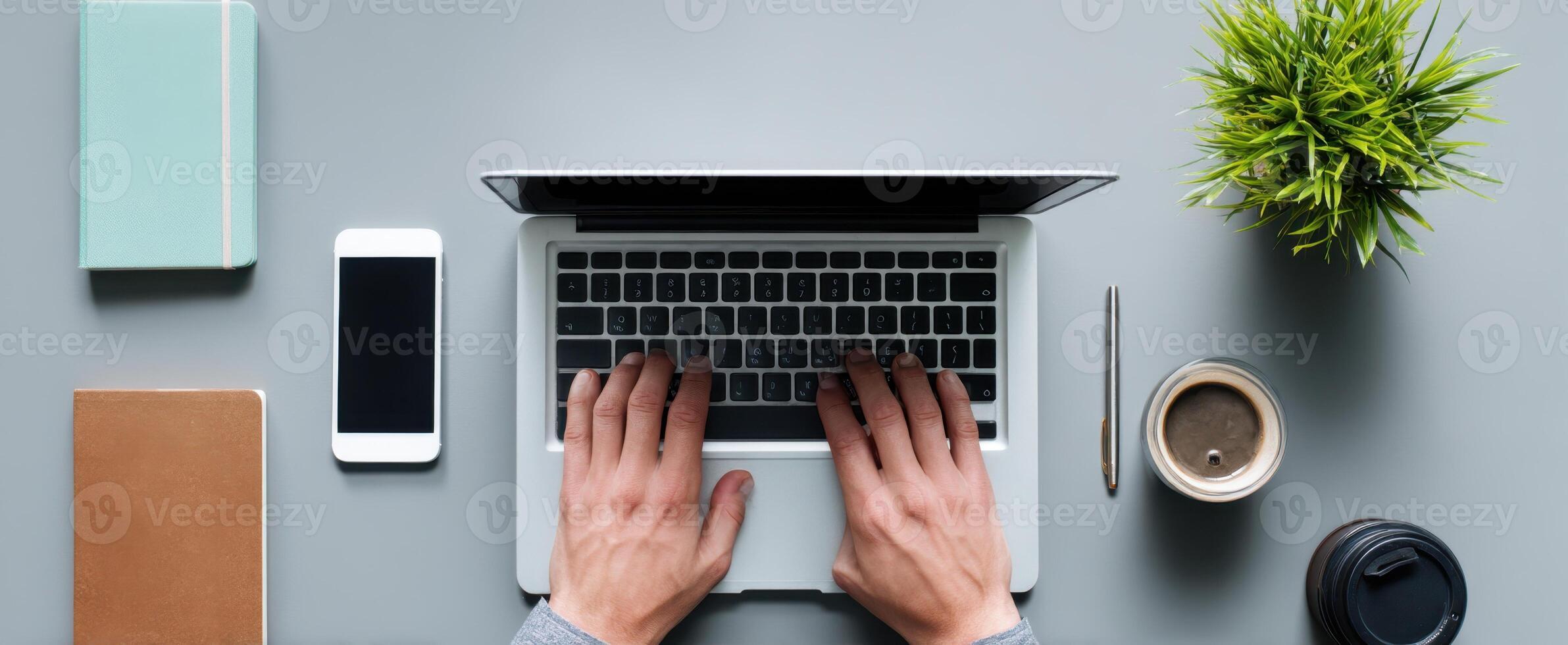 The laptop with hands typing on a modern workspace desk setup. photo