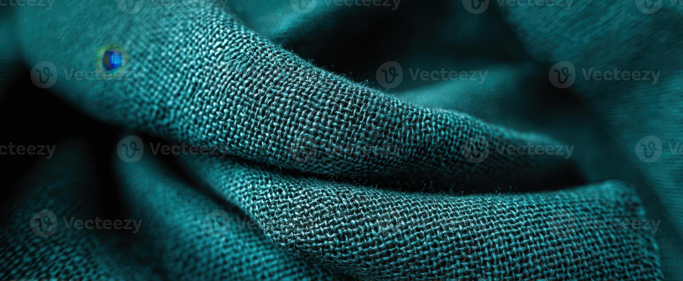 The rich texture of teal fabric showcasing intricate weave and soft drapery. photo