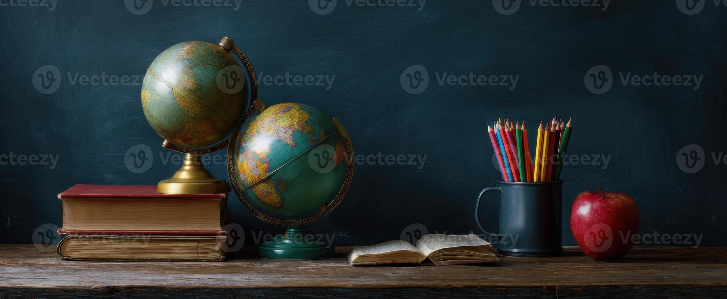 The globe and books create an inviting learning environment on a wooden desk. photo