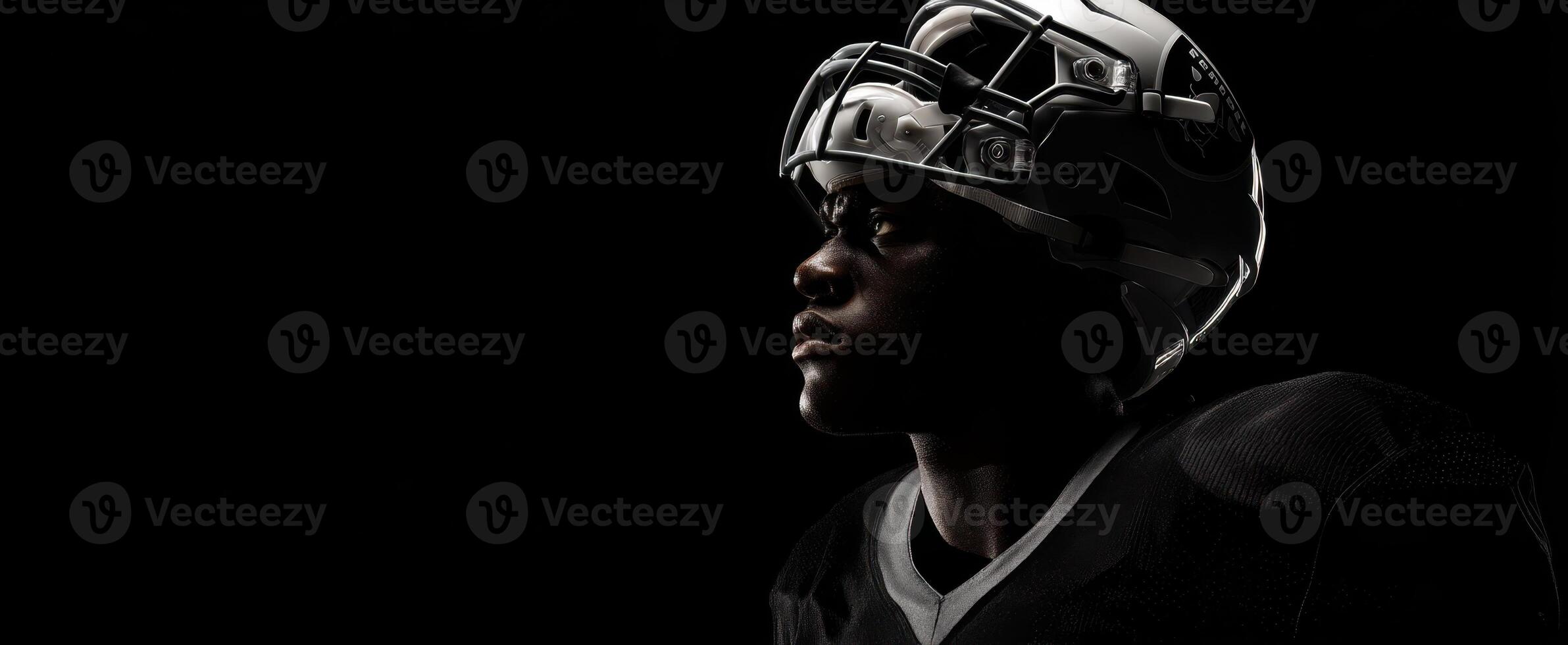 The determined football player in a dramatic profile against a dark background. photo