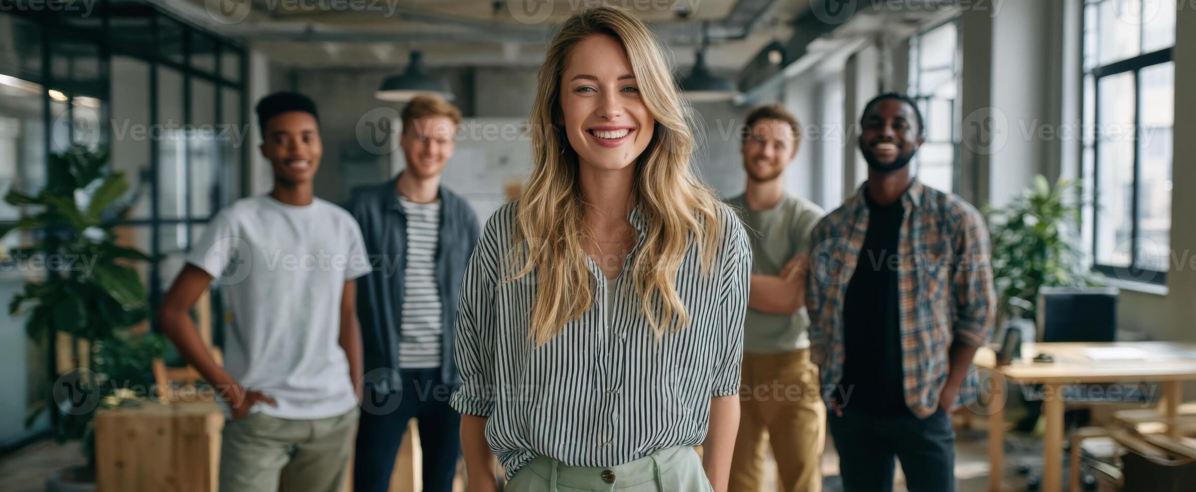 The vibrant group of young professionals smiling together in a modern office environment. photo