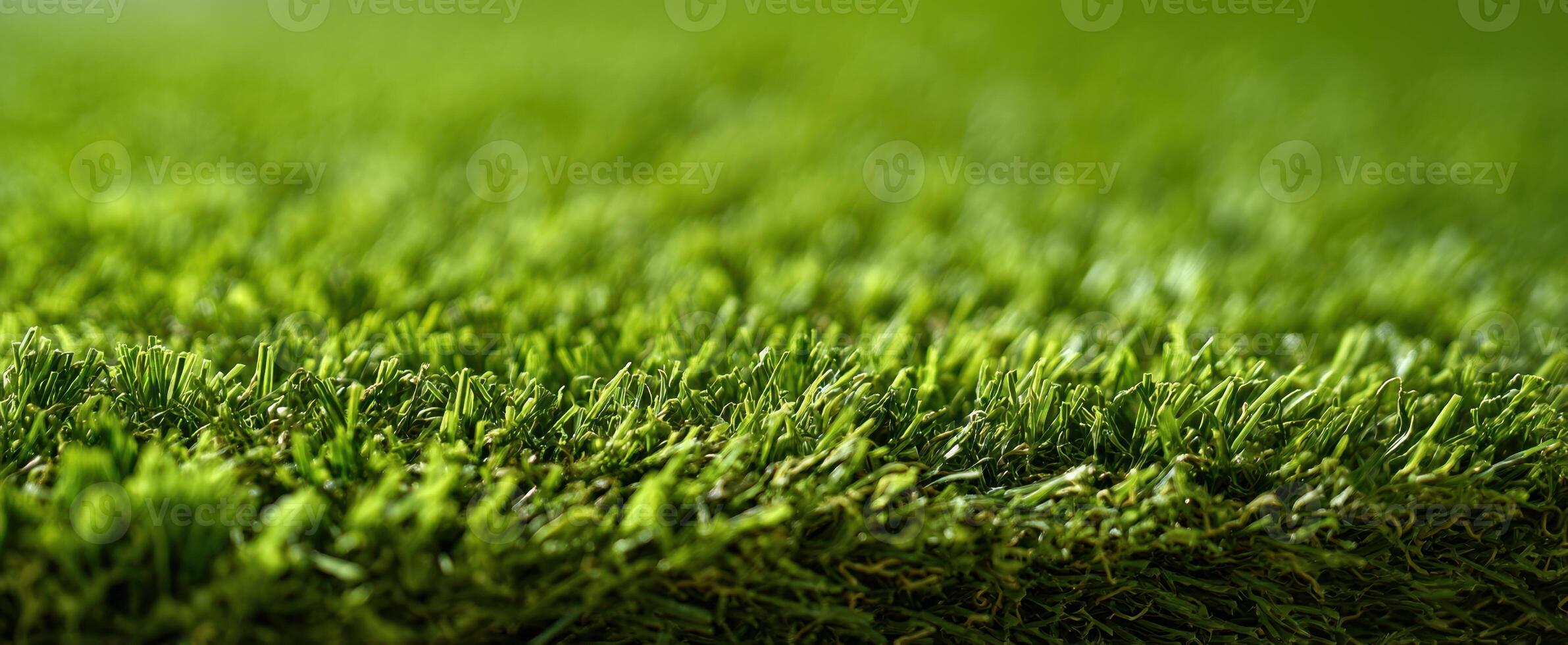 The vibrant green blades of artificial grass creating a lush, textured background. photo