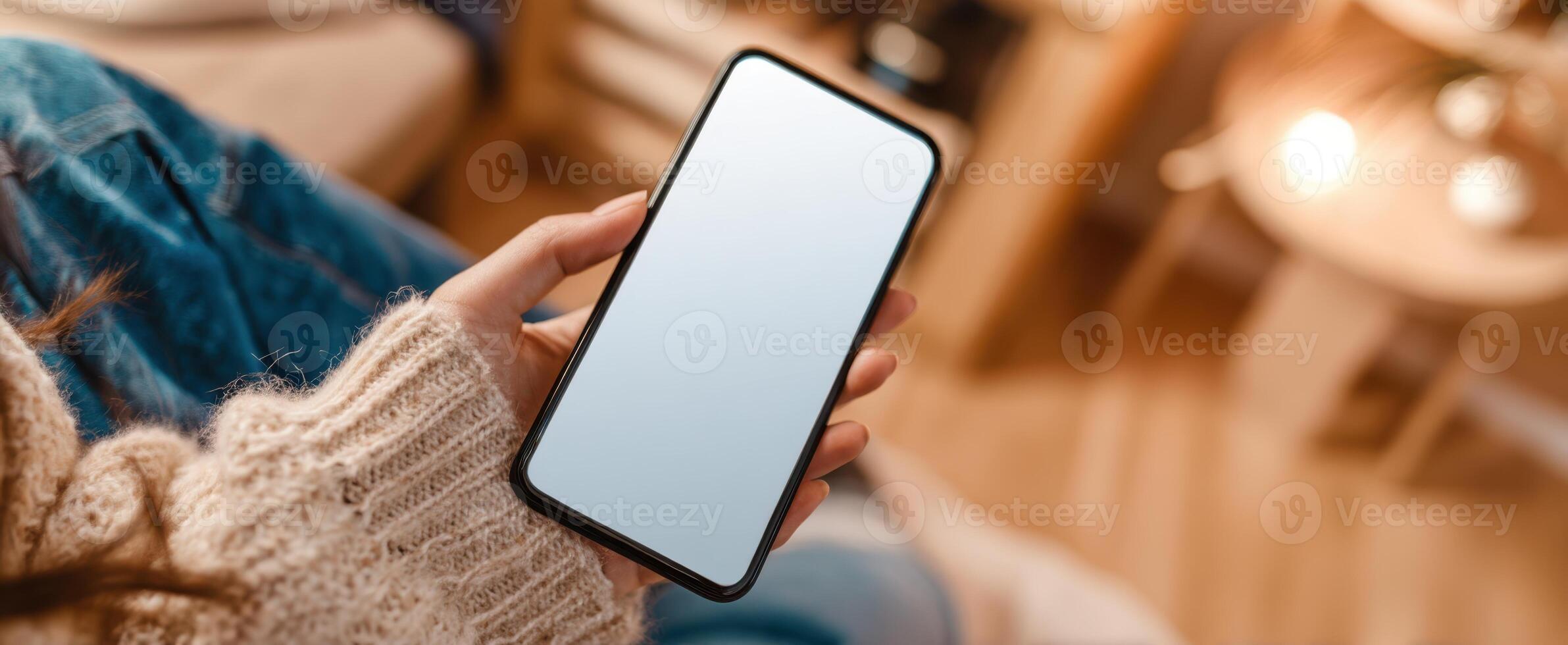 The smartphone in the hand of a cozy individual sitting indoors. photo