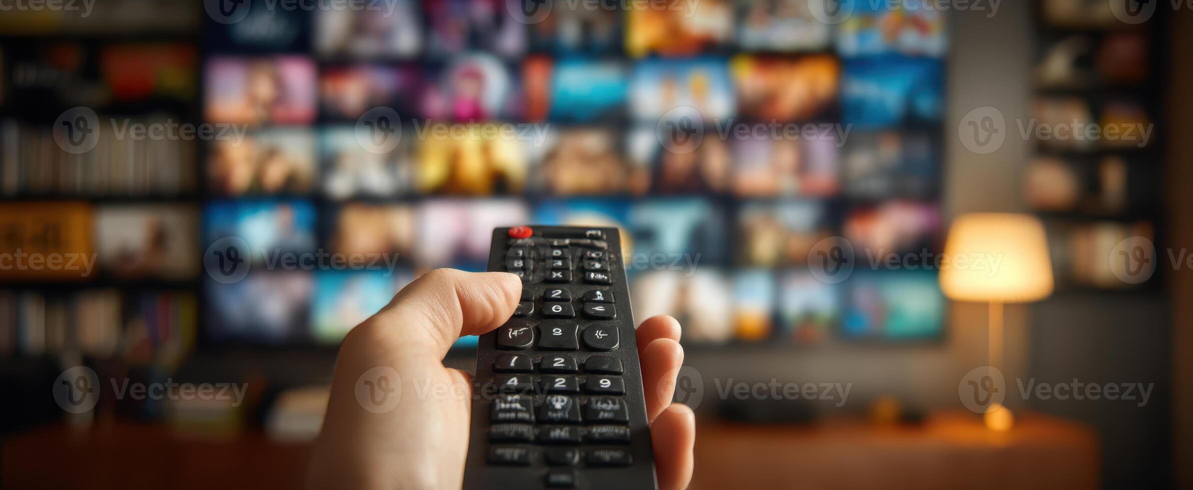 A person holding a remote control in front of a television photo