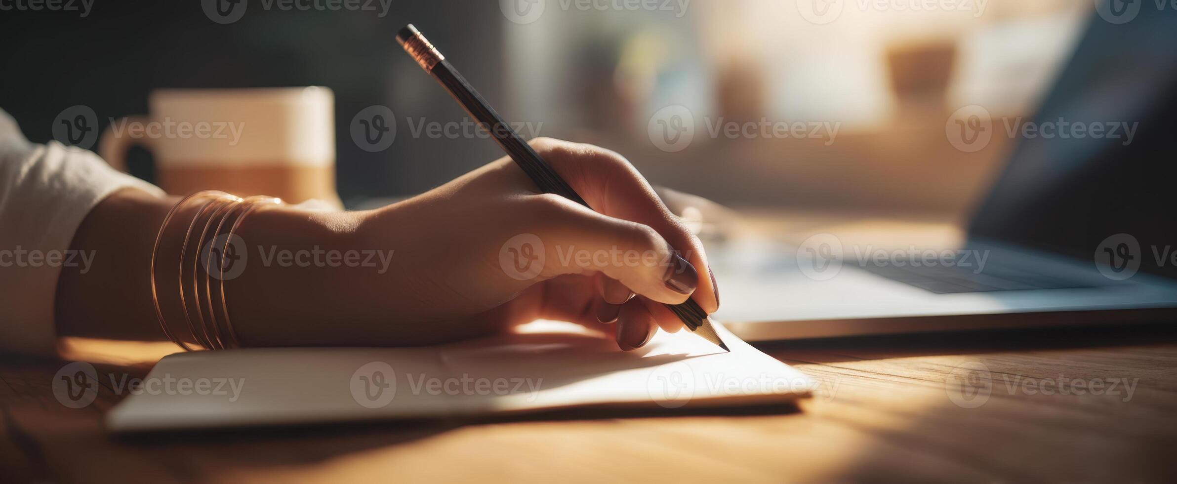 The hand writing in a notebook with a serene coffee setting. photo