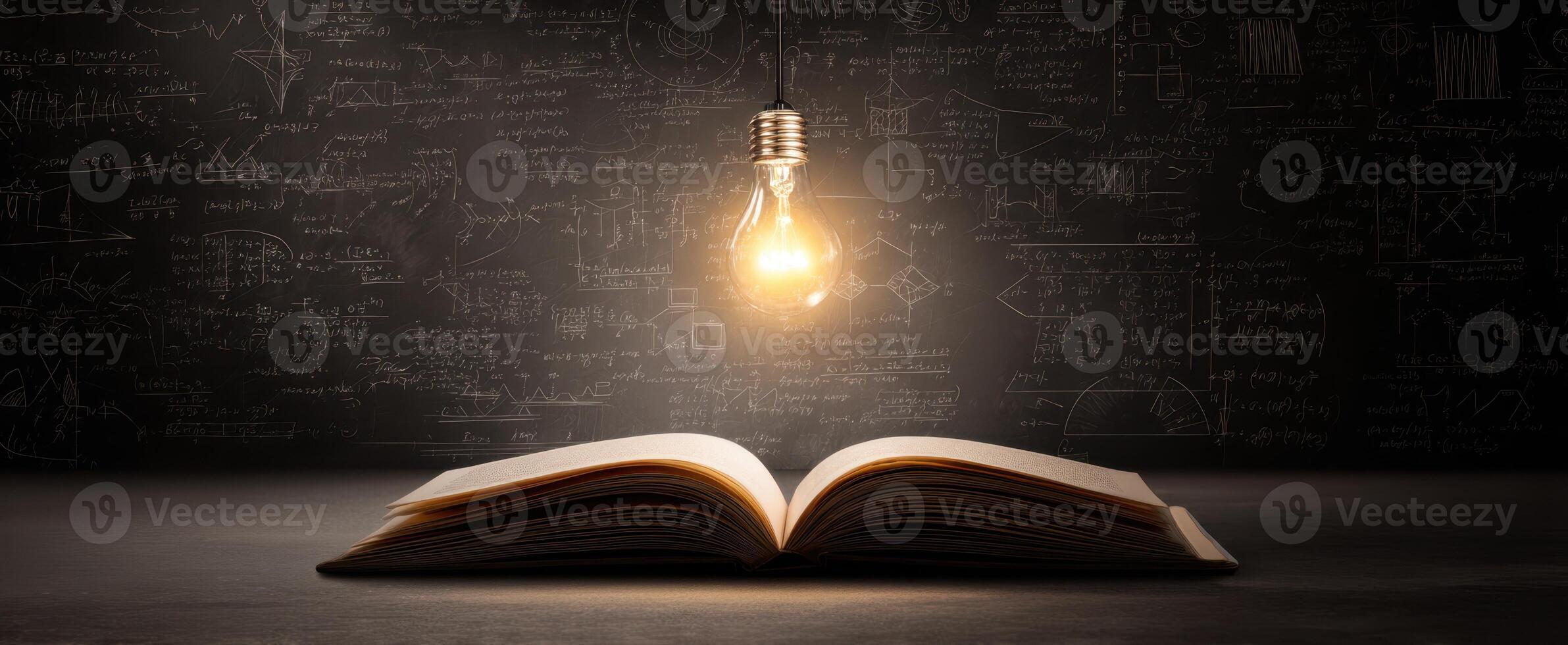 The open book illuminated by a glowing lightbulb against a chalkboard background. photo