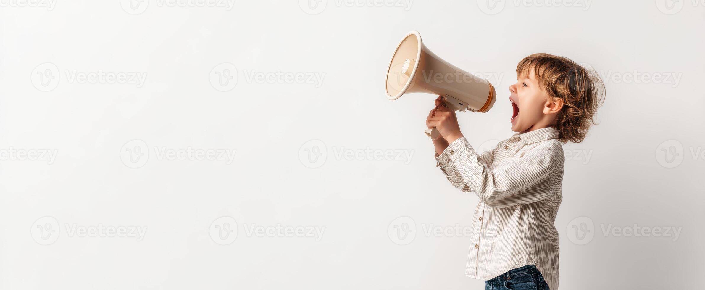The young boy enthusiastically speaking into a megaphone on a plain background. photo
