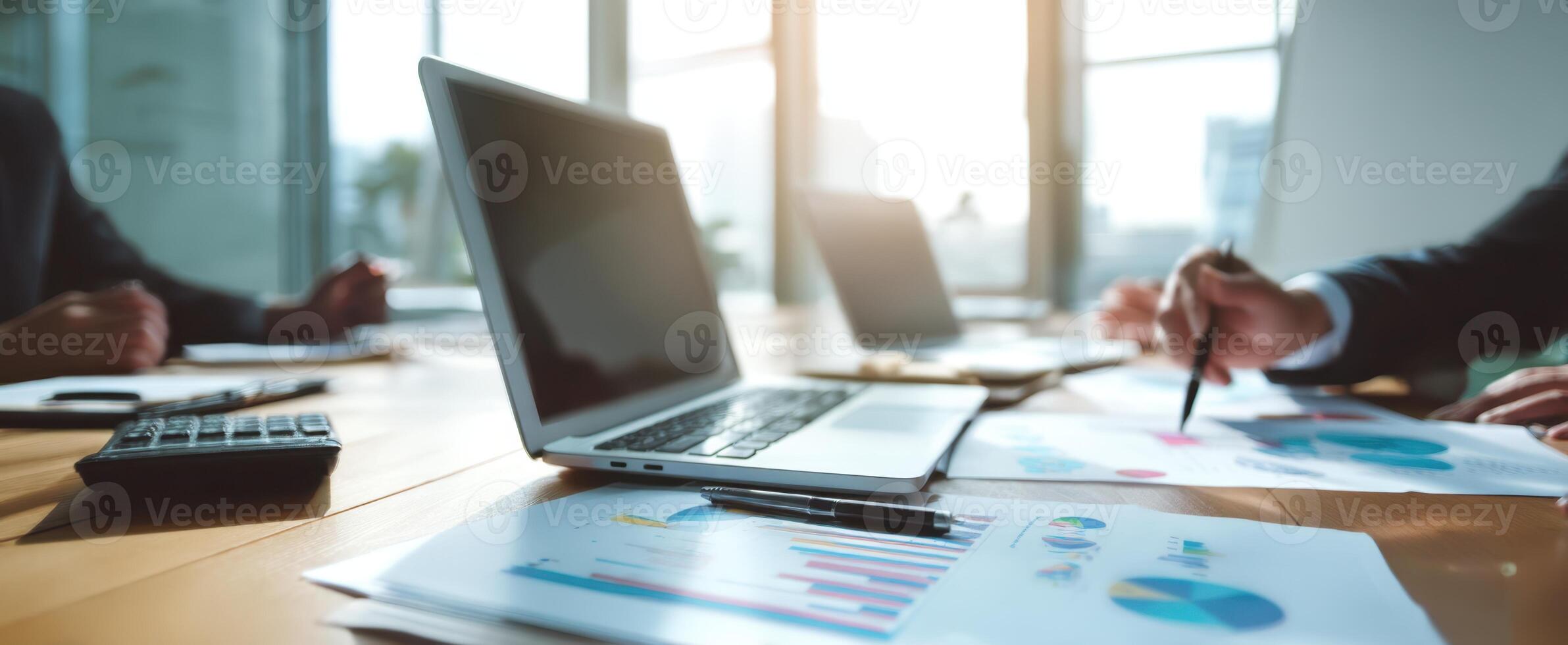 The modern workspace with laptop and financial documents during a meeting. photo
