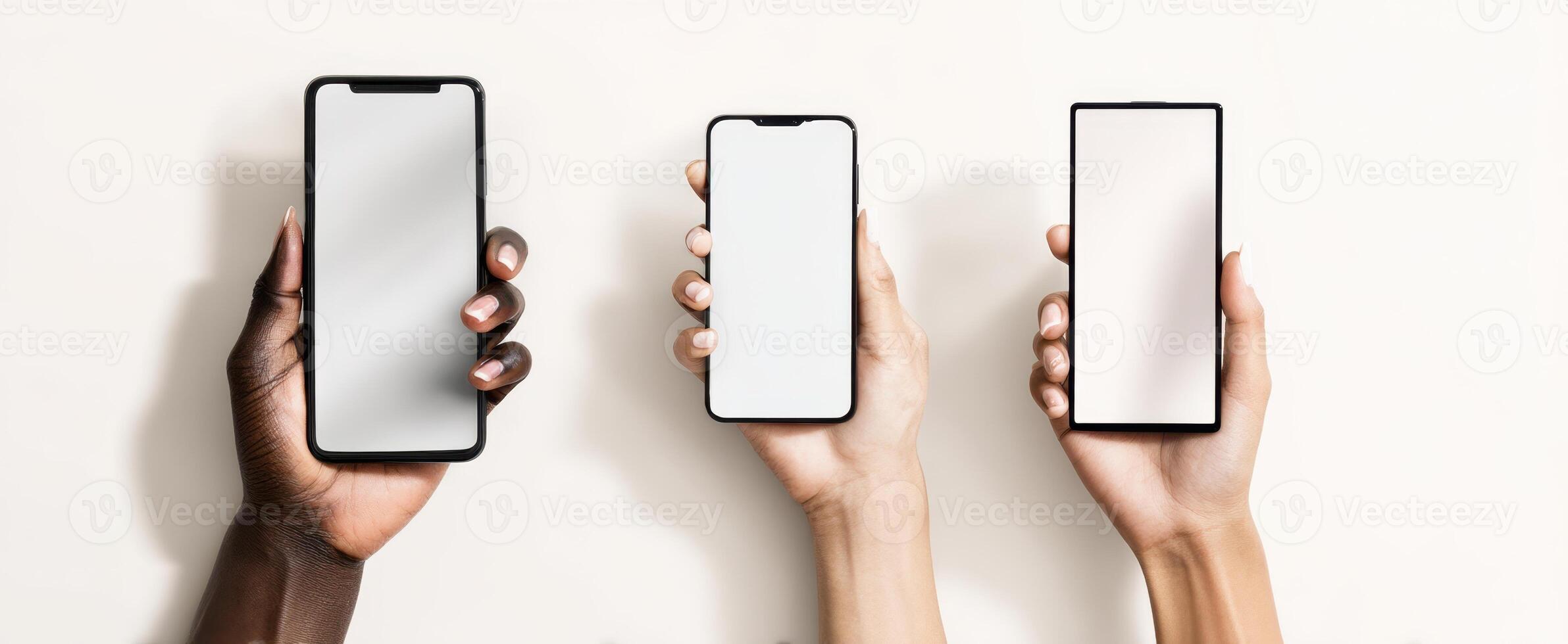 The collection of smartphones held by diverse hands against a light background photo