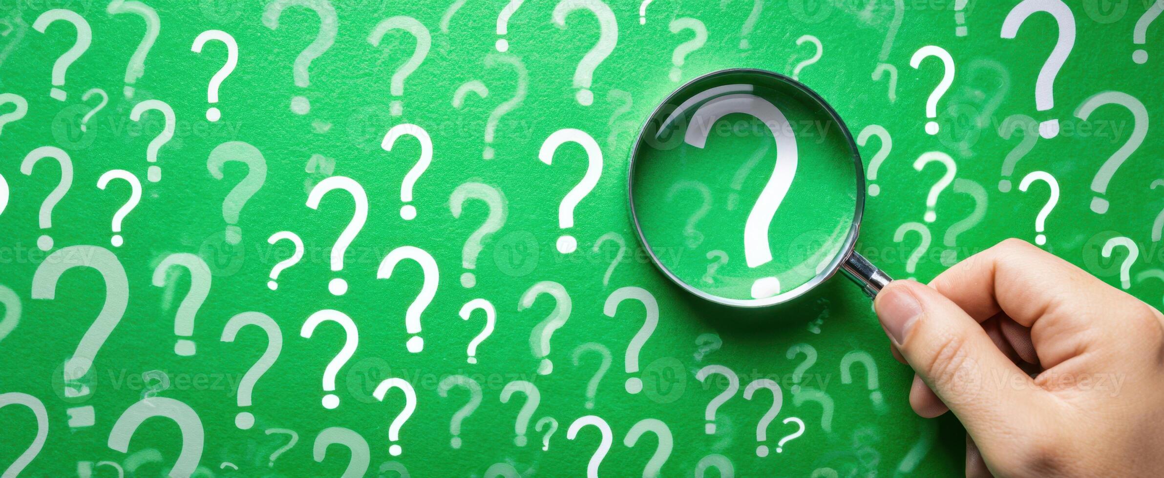 The magnifying glass highlighting questions on a green background. photo
