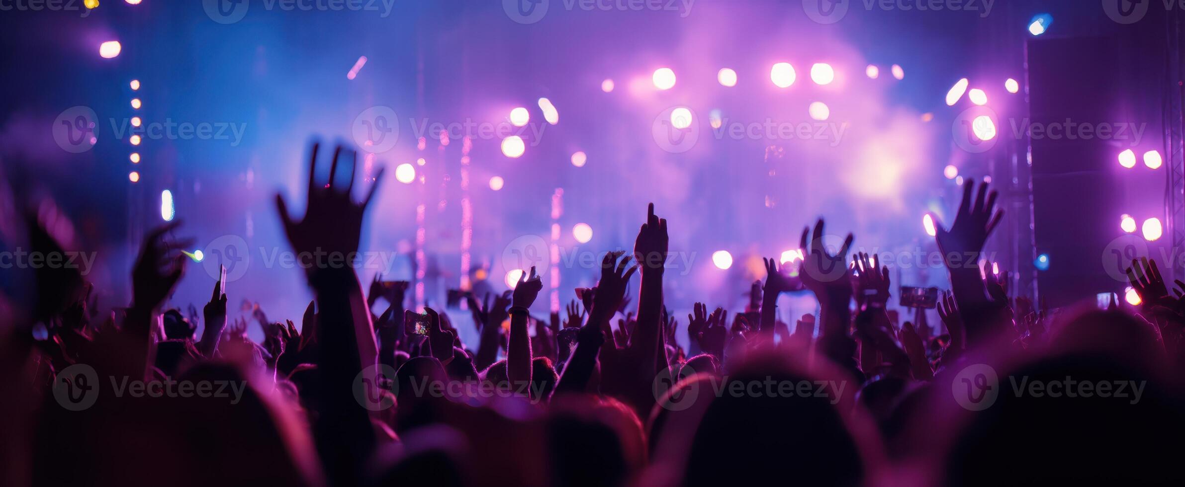 The vibrant hands of a lively crowd at a concert under colorful lights. photo
