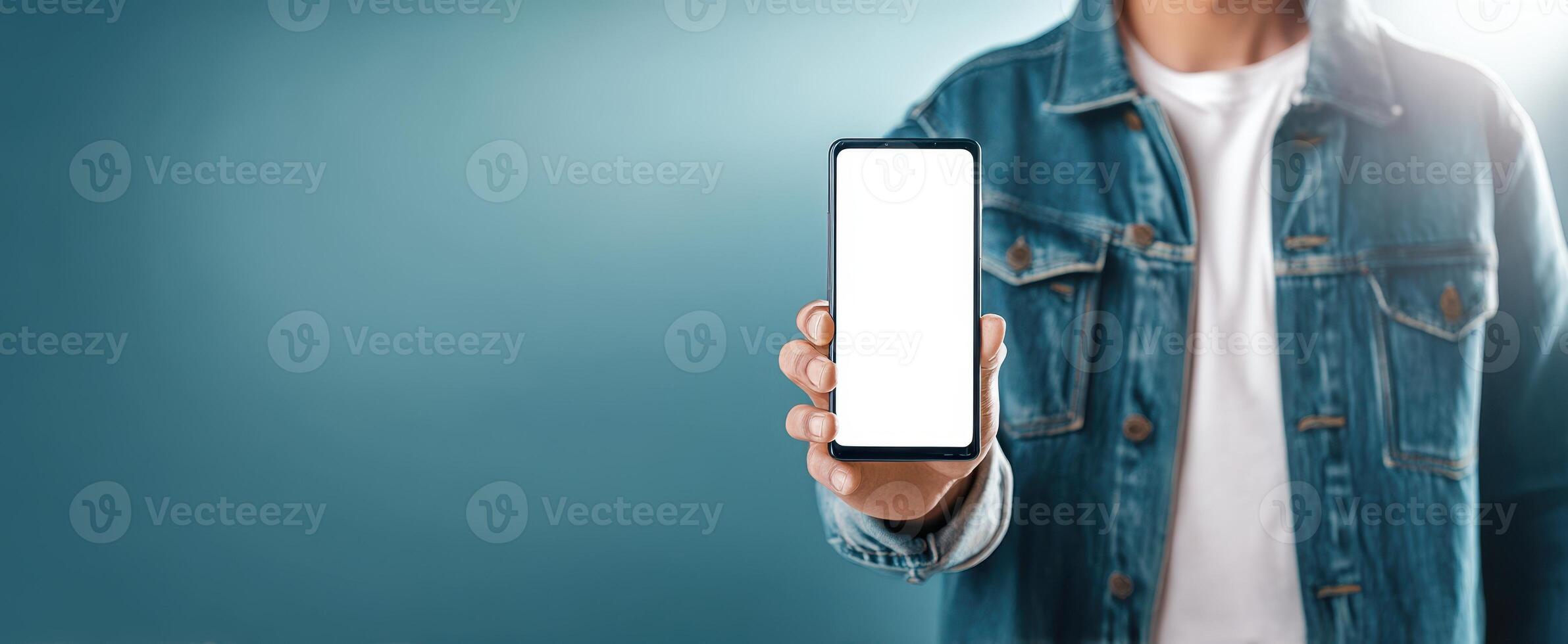 The smartphone device presented by a young person in a casual setting. photo