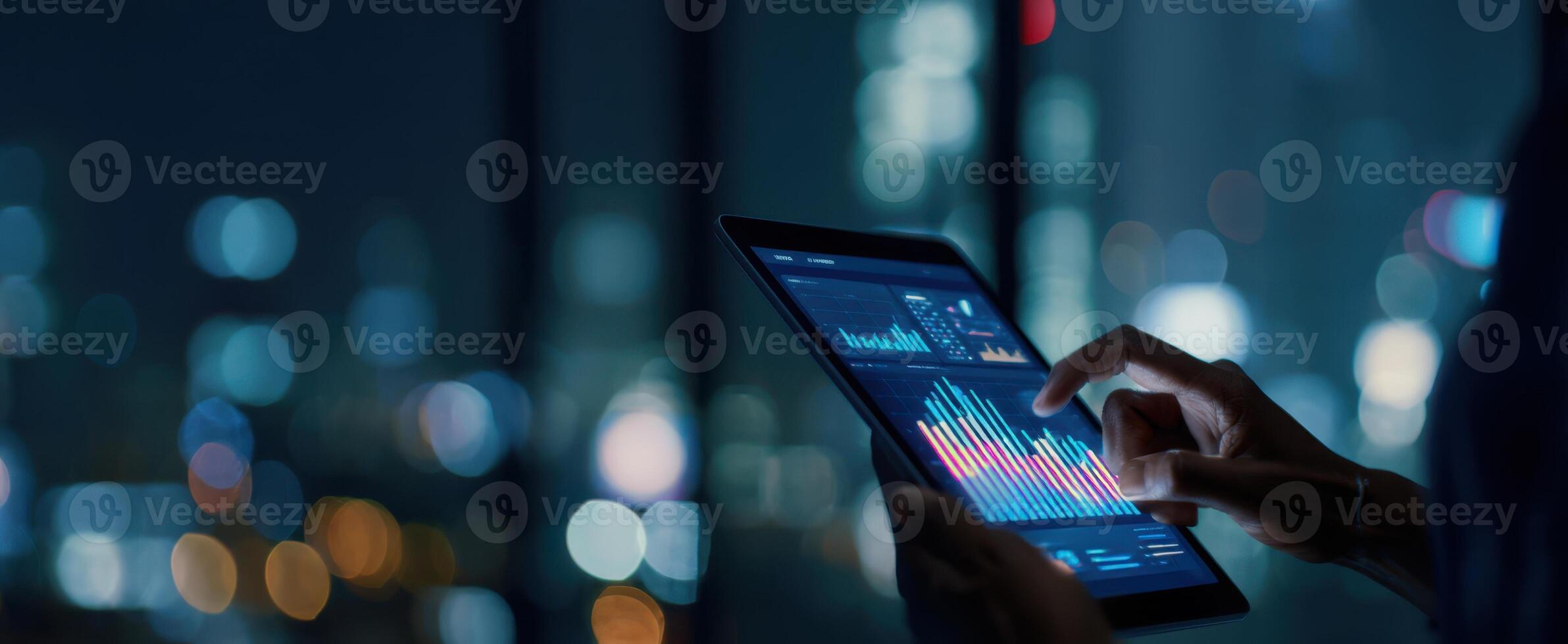 The tablet displaying financial data in a modern urban office at night. photo