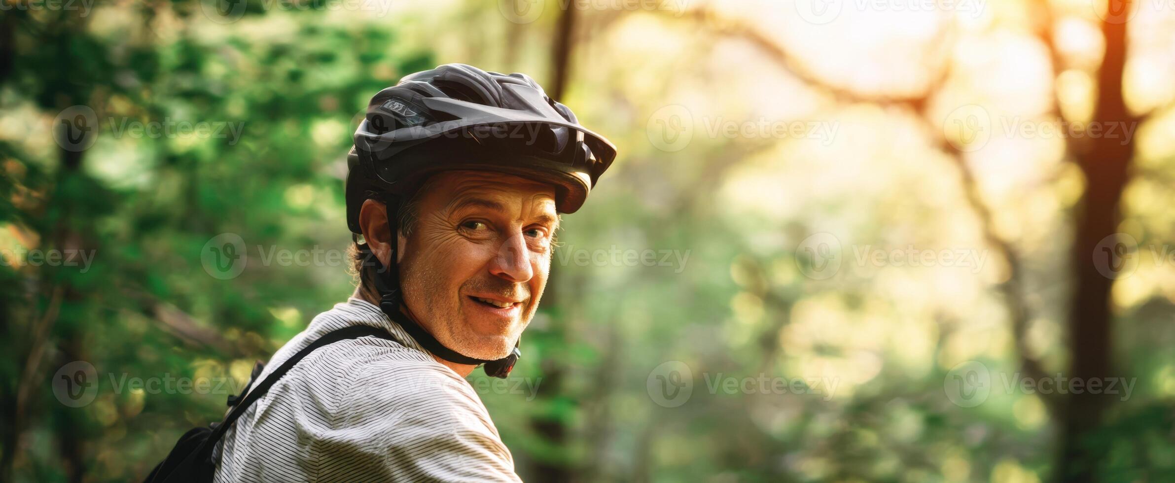 The cyclist enjoys a sunny ride through a lush forest trail. photo