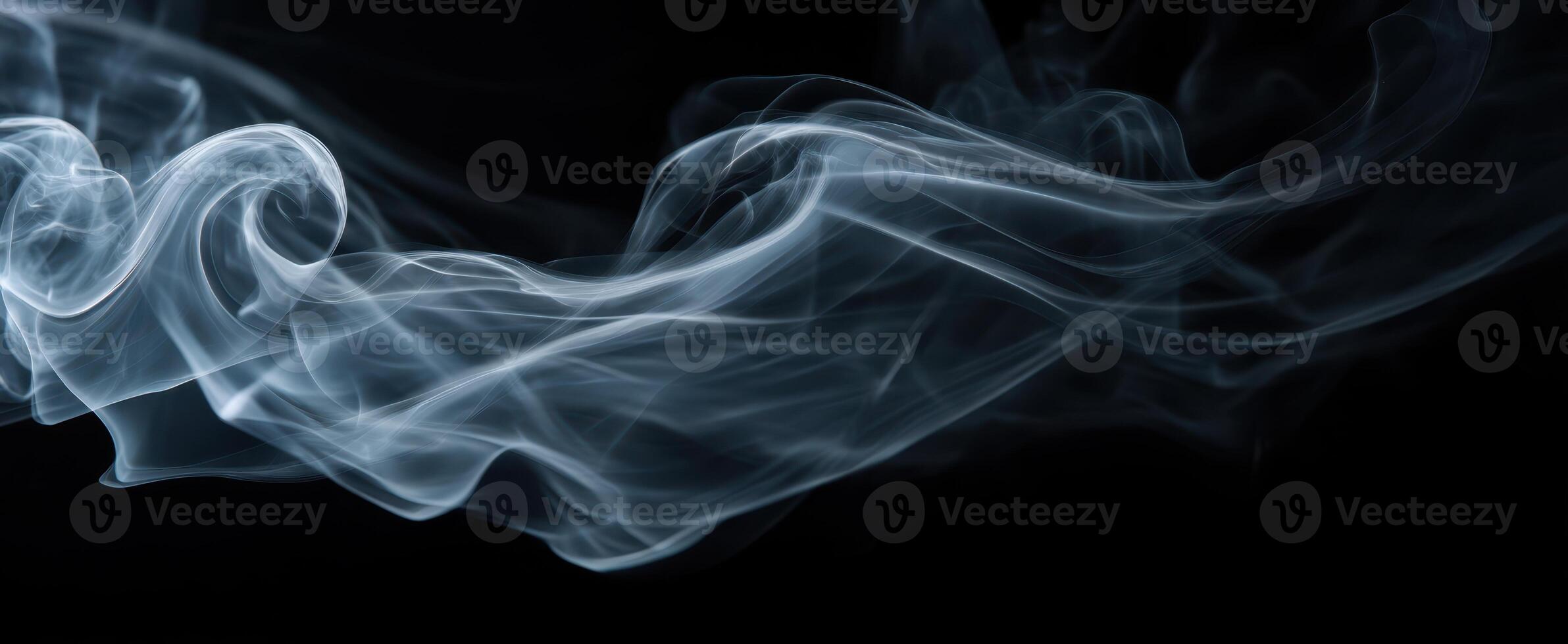 The graceful dance of smoke swirling in the air on a dark background. photo