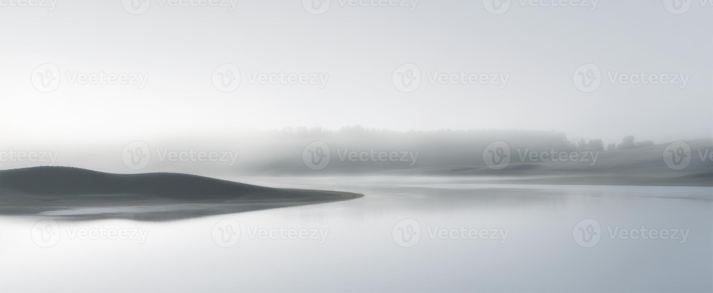 The tranquil fog envelops a serene river and gentle landscape. photo