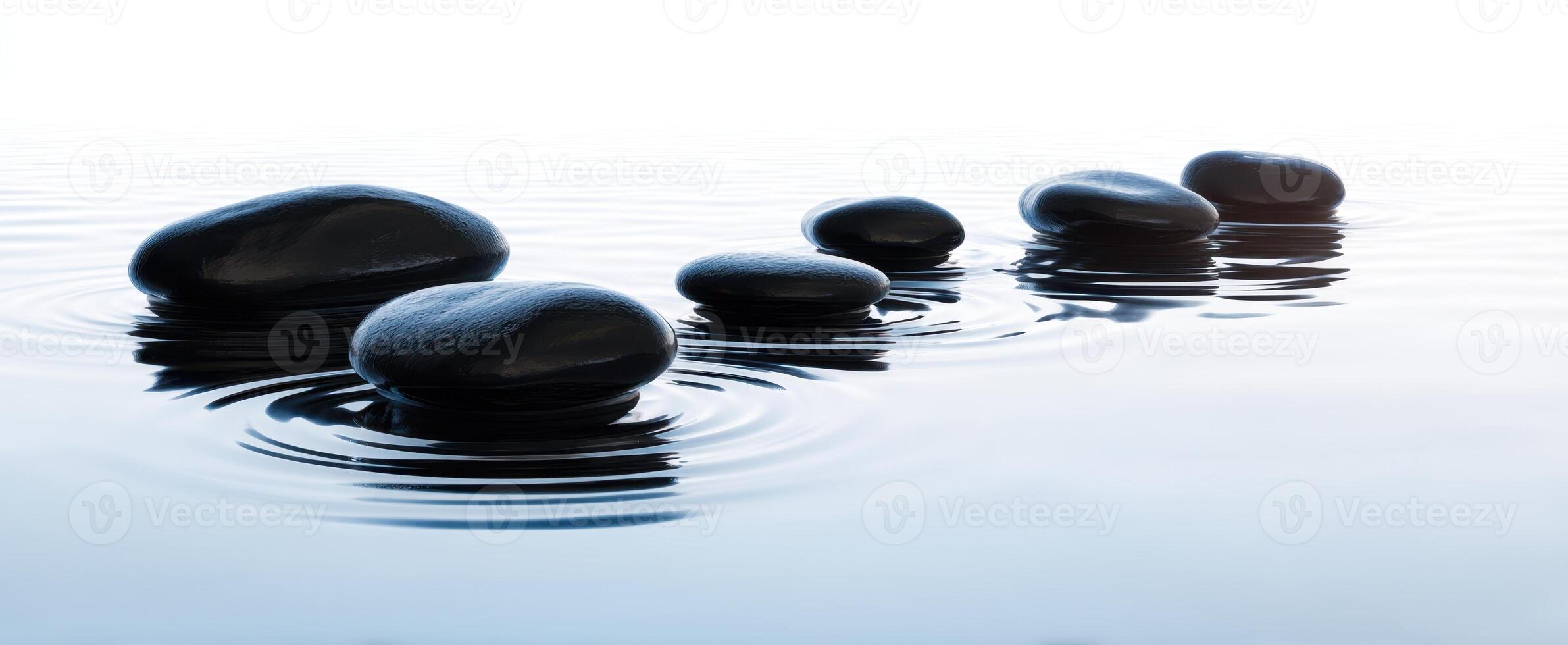 The serene arrangement of smooth stones in tranquil water setting. photo