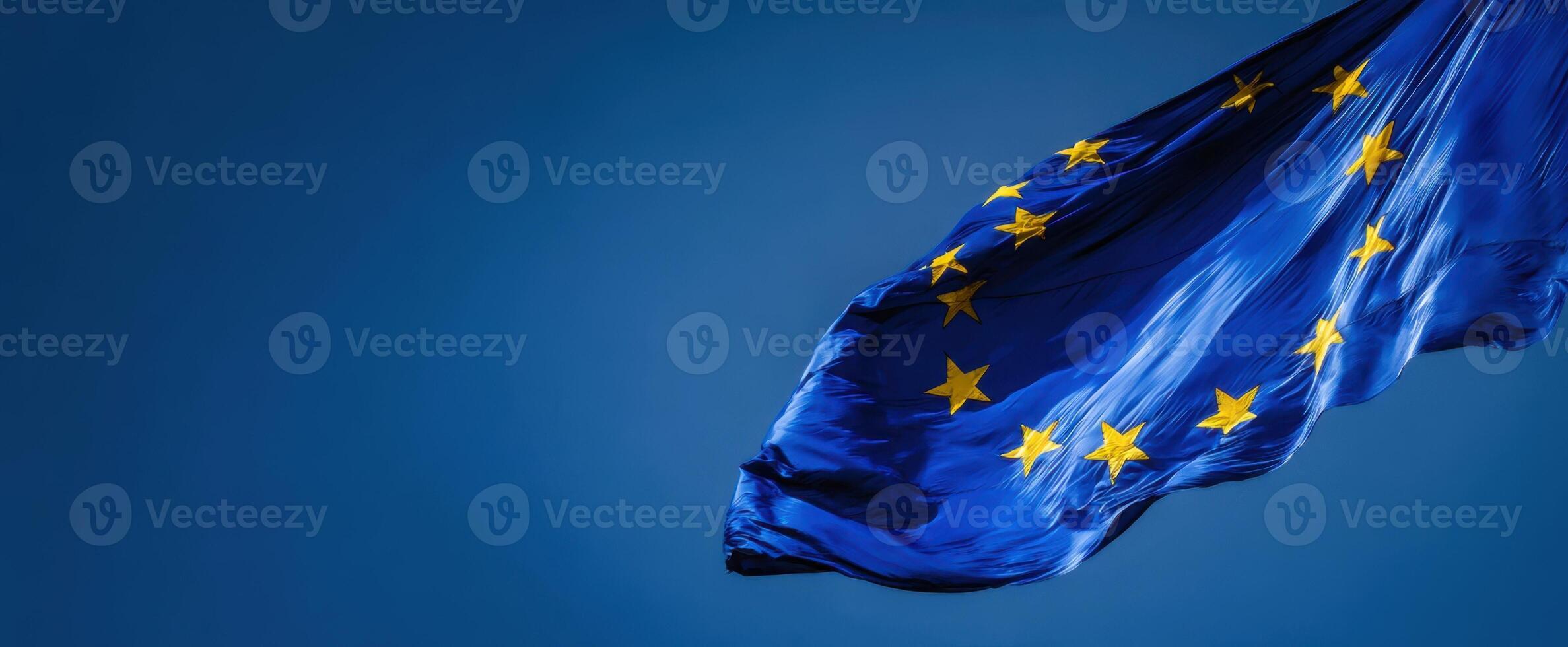 The European Union flag waving gracefully in a clear blue sky. photo