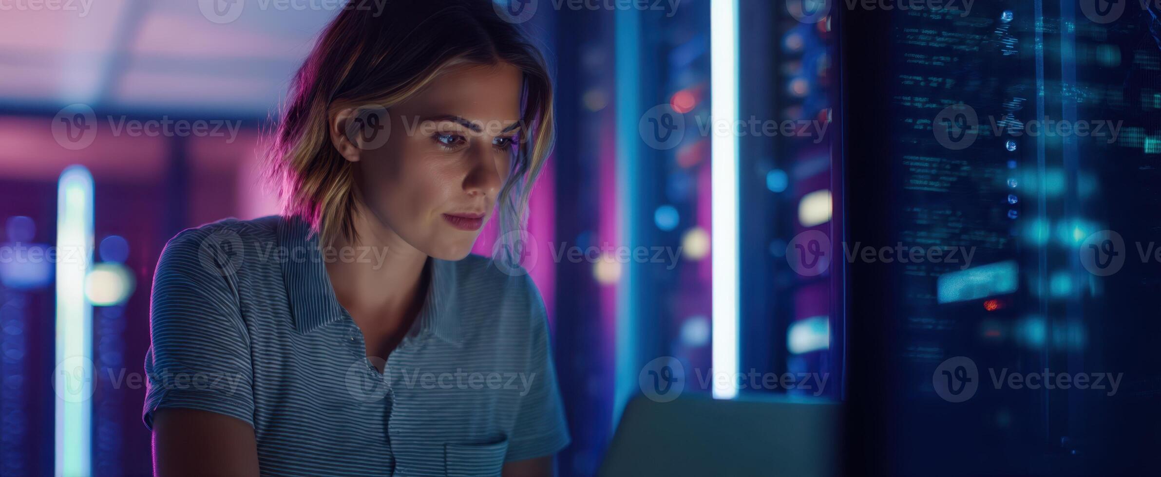 The woman analyzing data in a vibrant, high-tech server room environment. photo