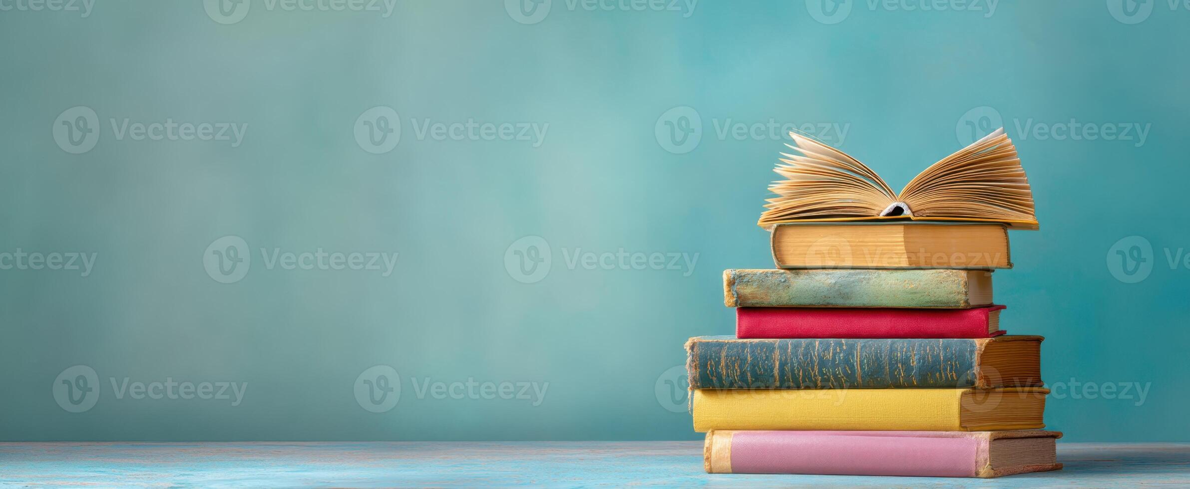 The stack of colorful books with an open page on top photo
