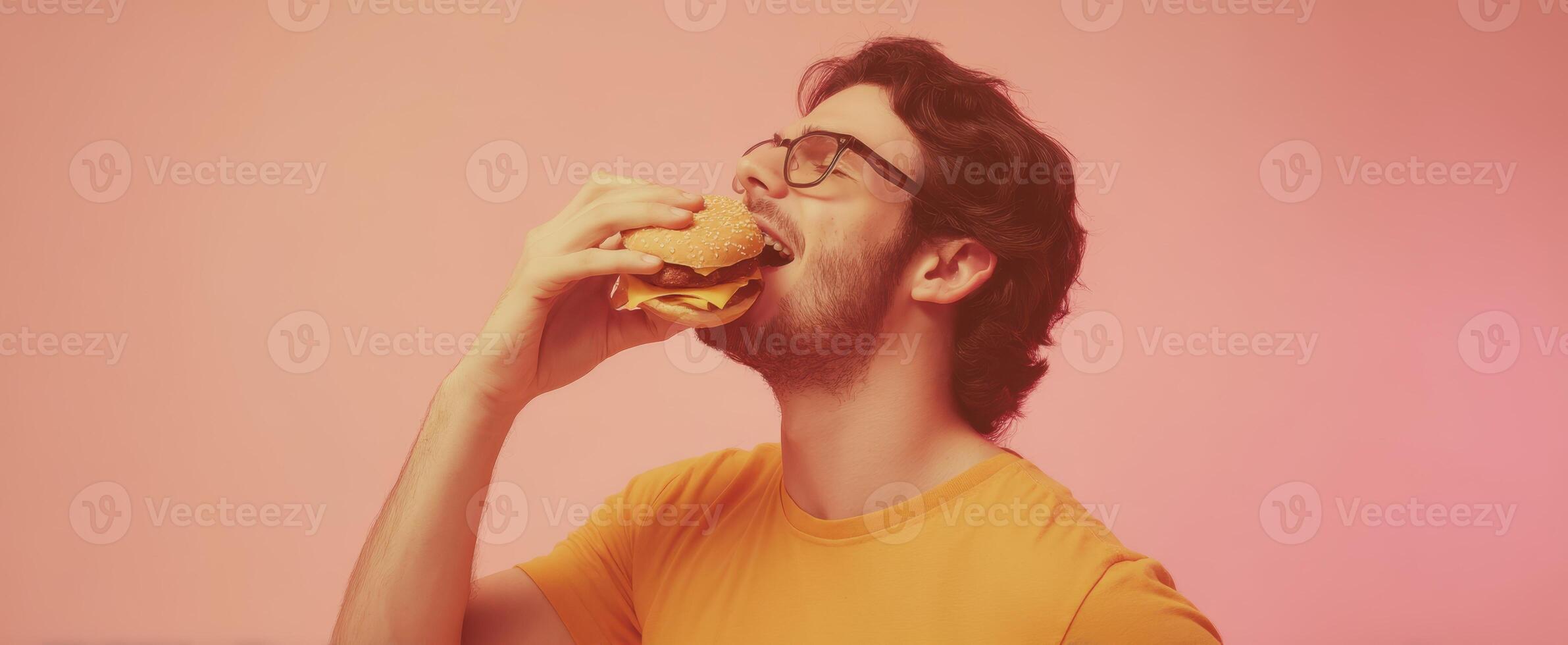 The man enjoying a delicious burger in a joyful and colorful setting. photo