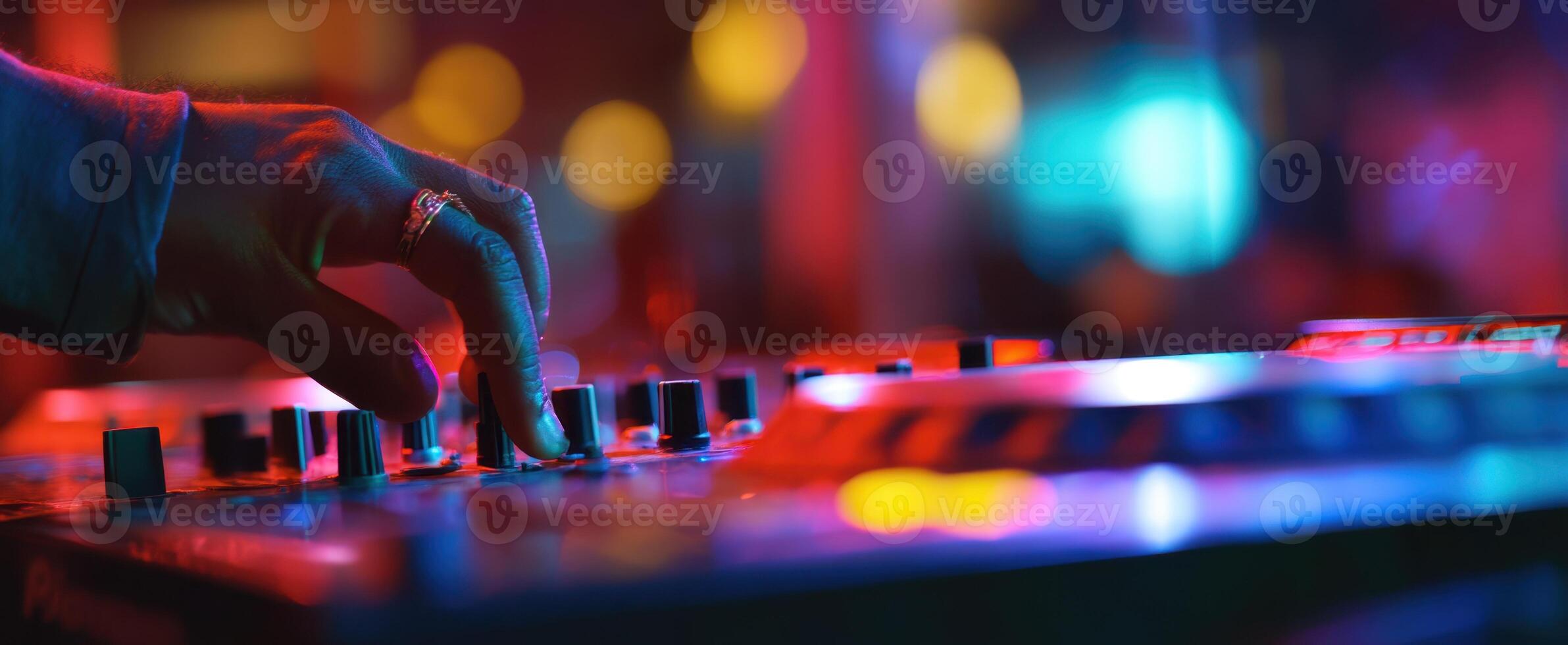 The DJ hand adjusting sound levels in a vibrant nightlife setting. photo
