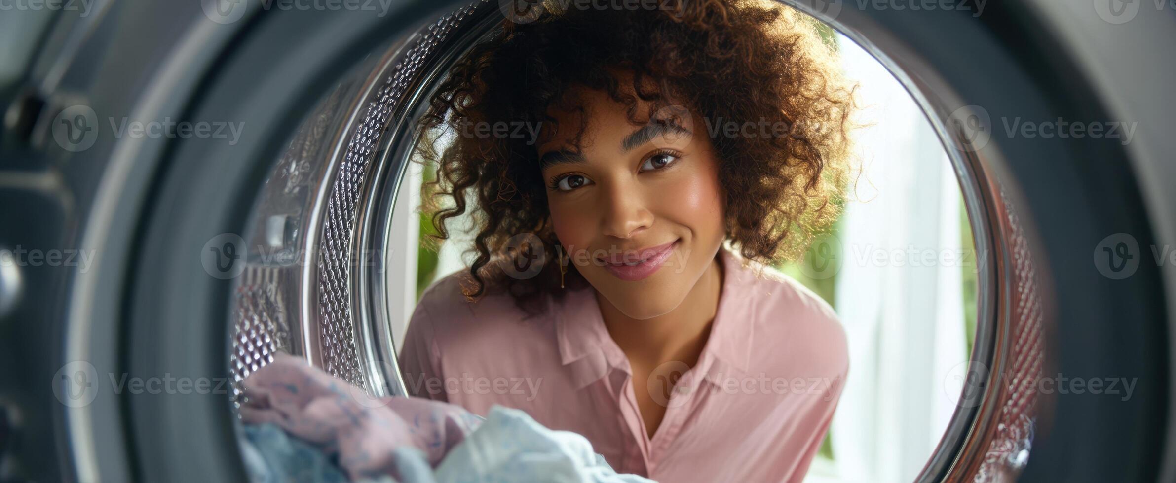The woman smiling from inside a washing machine with vibrant domestic atmosphere. photo