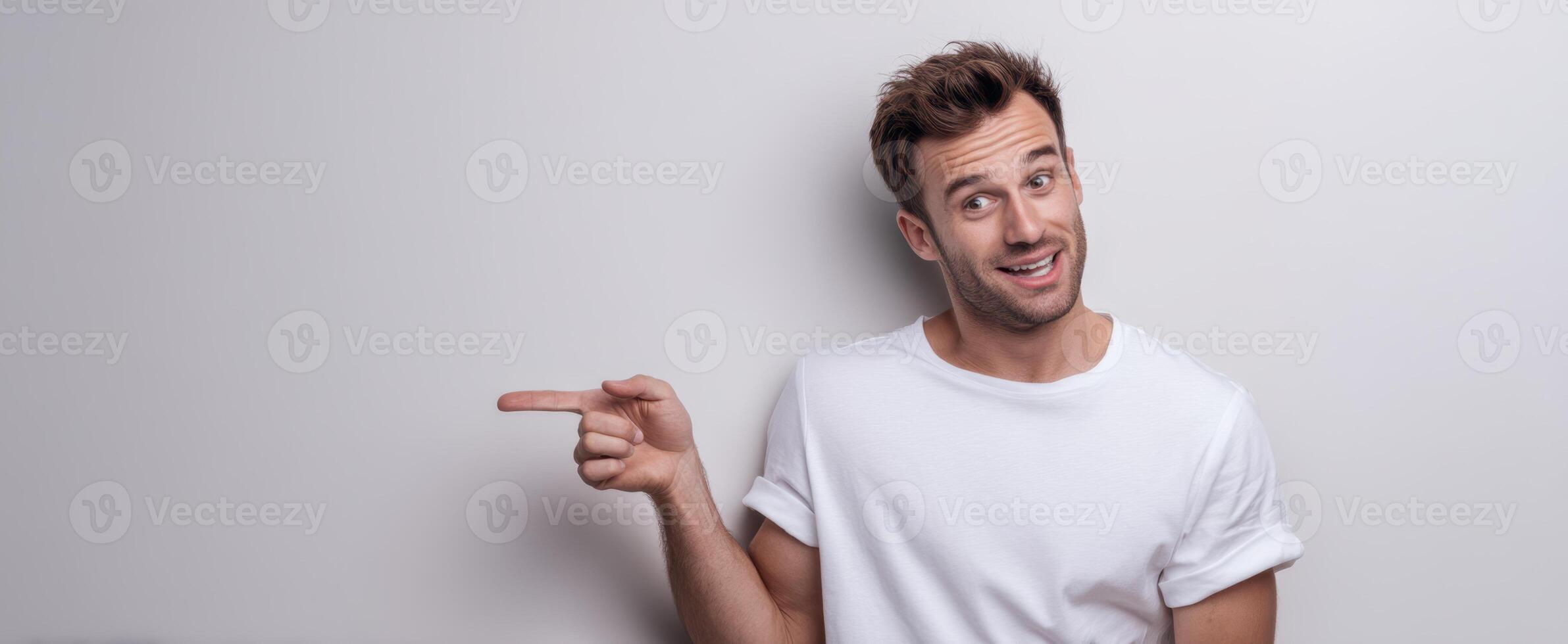 The smiling man pointing happily against a plain background. photo