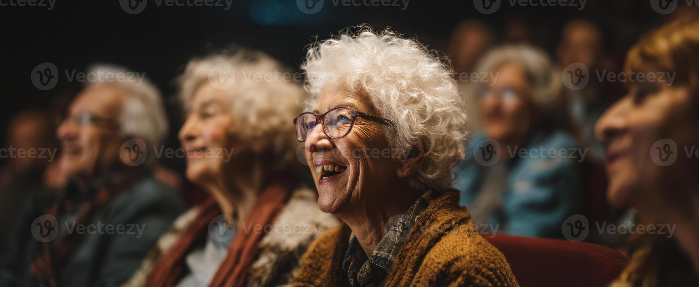 The joyous seniors enjoying a lively performance together in a theater setting. photo