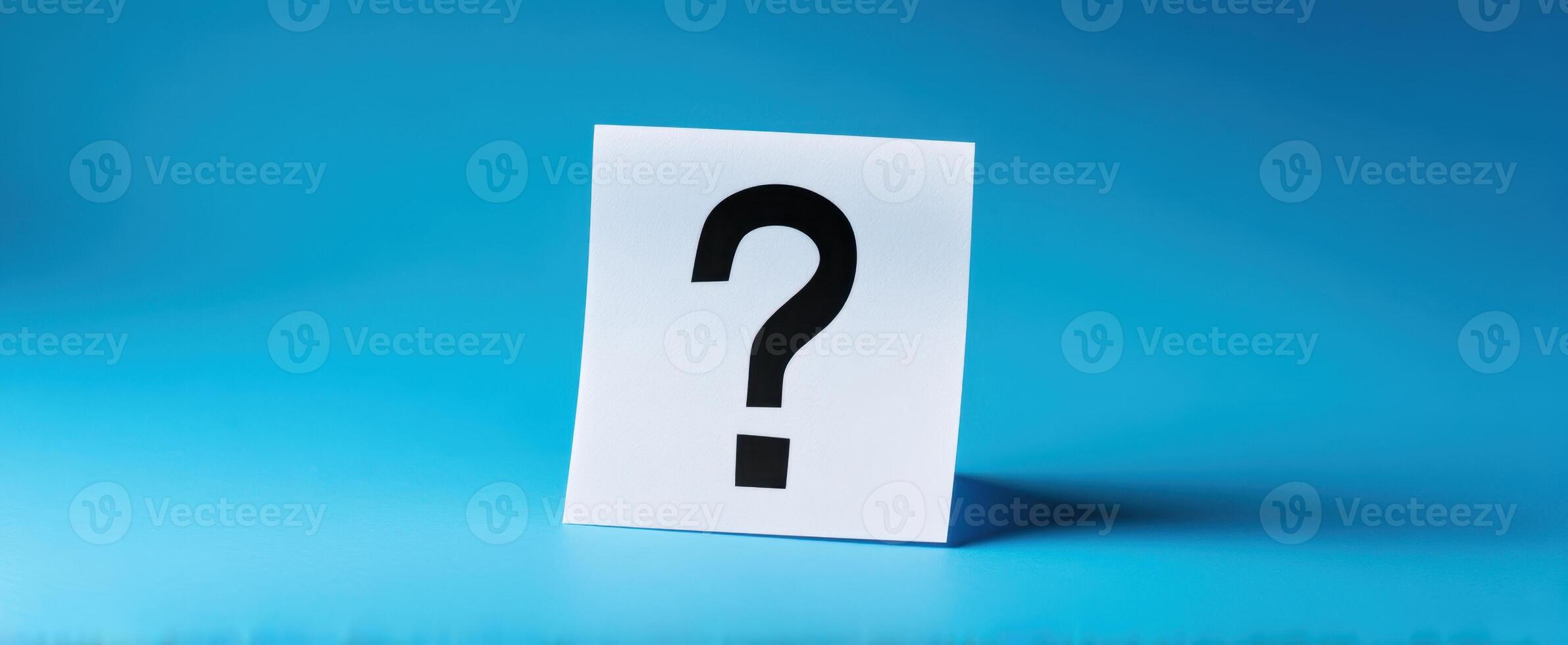The question mark on a sticky note against a serene blue backdrop. photo
