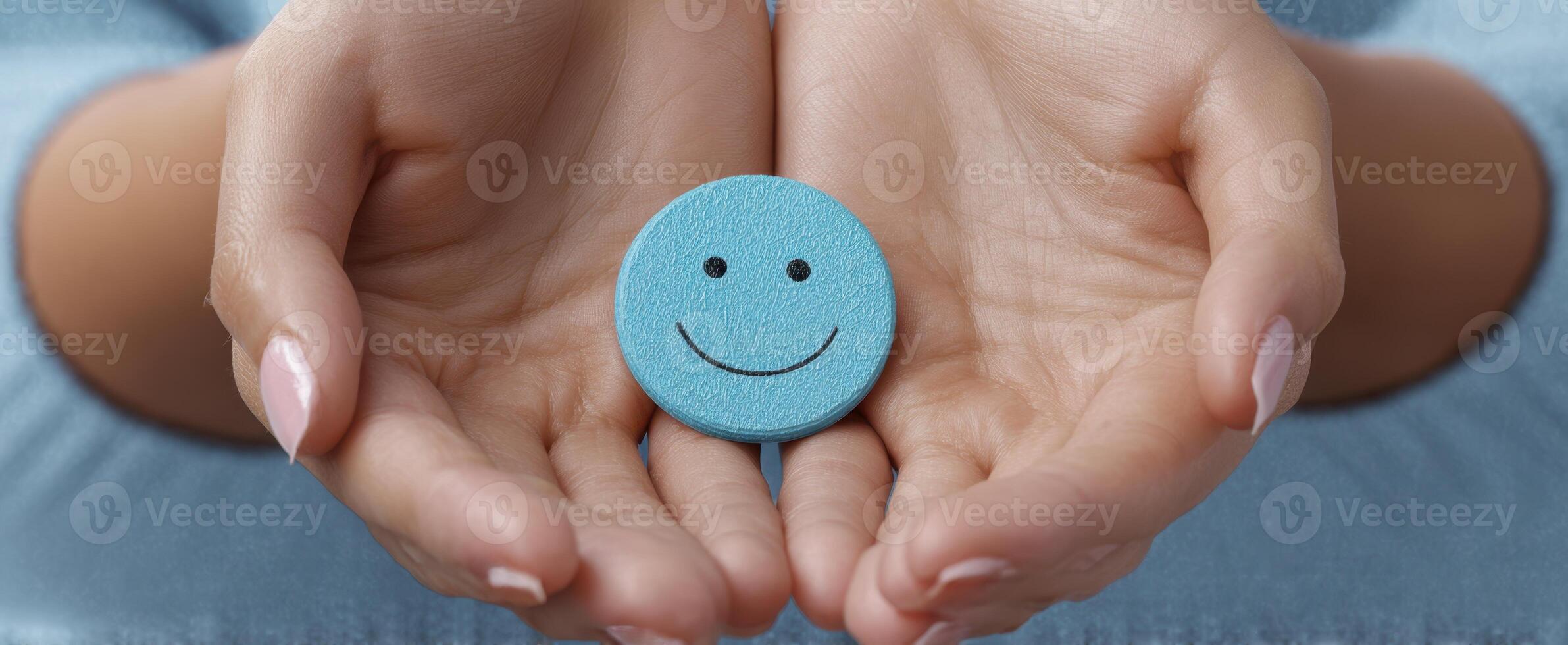 The hands holding a blue smiley face symbolizing positivity and joy photo