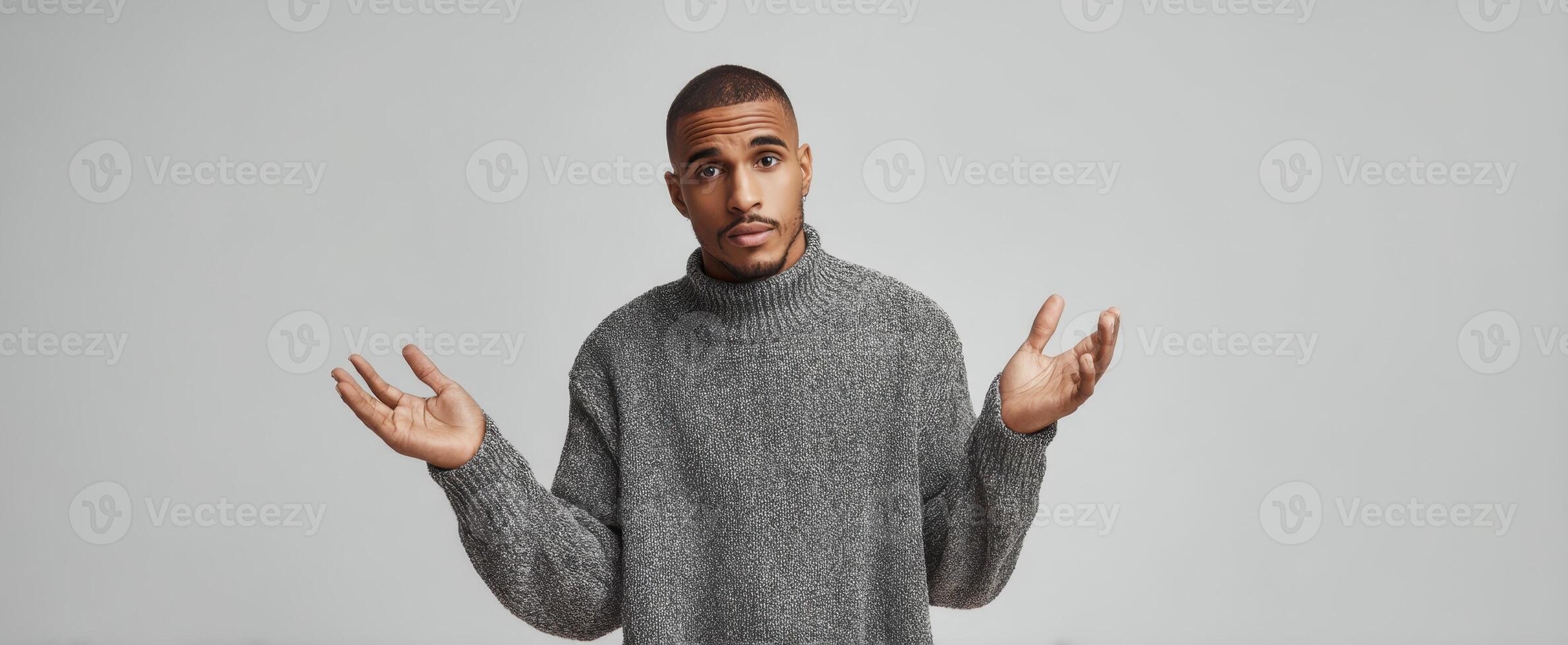 The man in a cozy gray sweater expressing confusion and uncertainty. photo