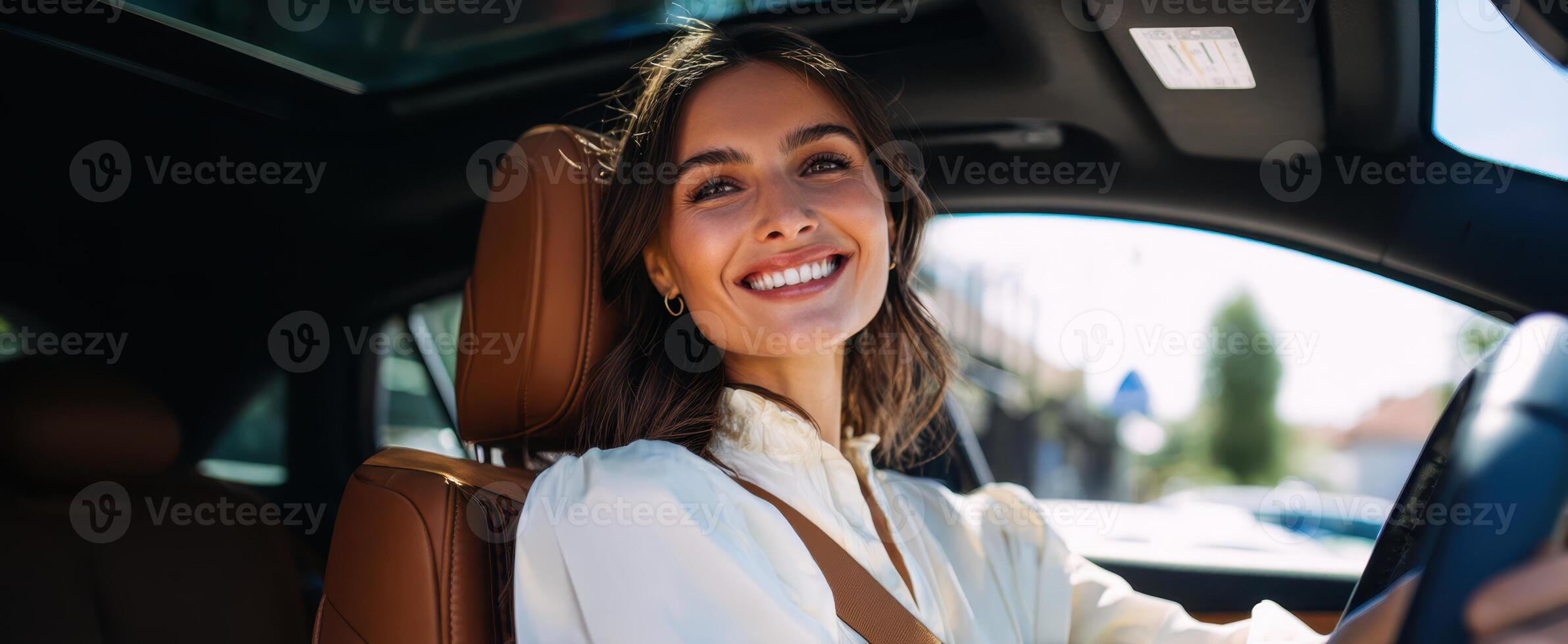 The woman smiling happily while driving a stylish car on a sunny day. photo