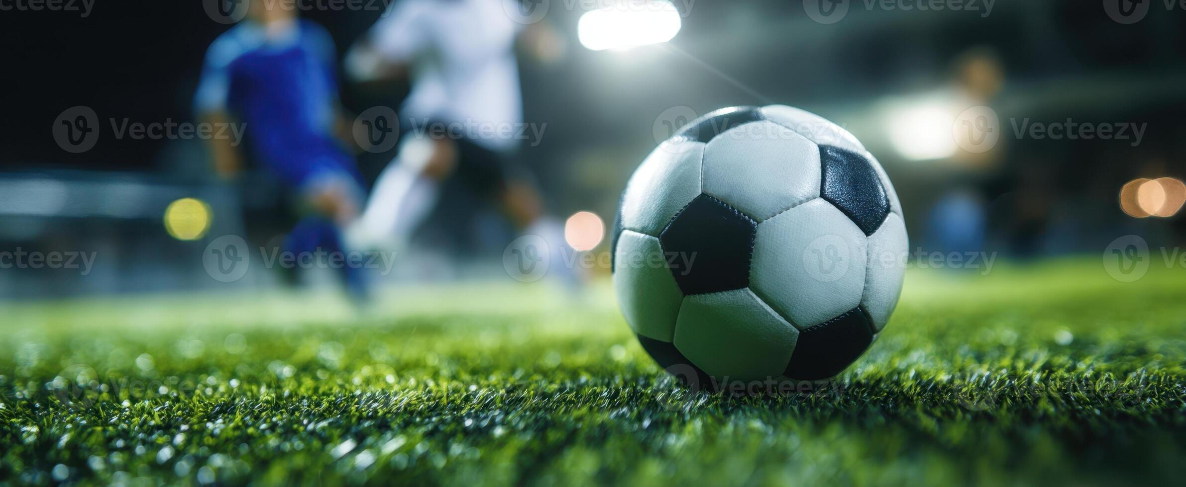The soccer ball on the grass during an intense night match. photo