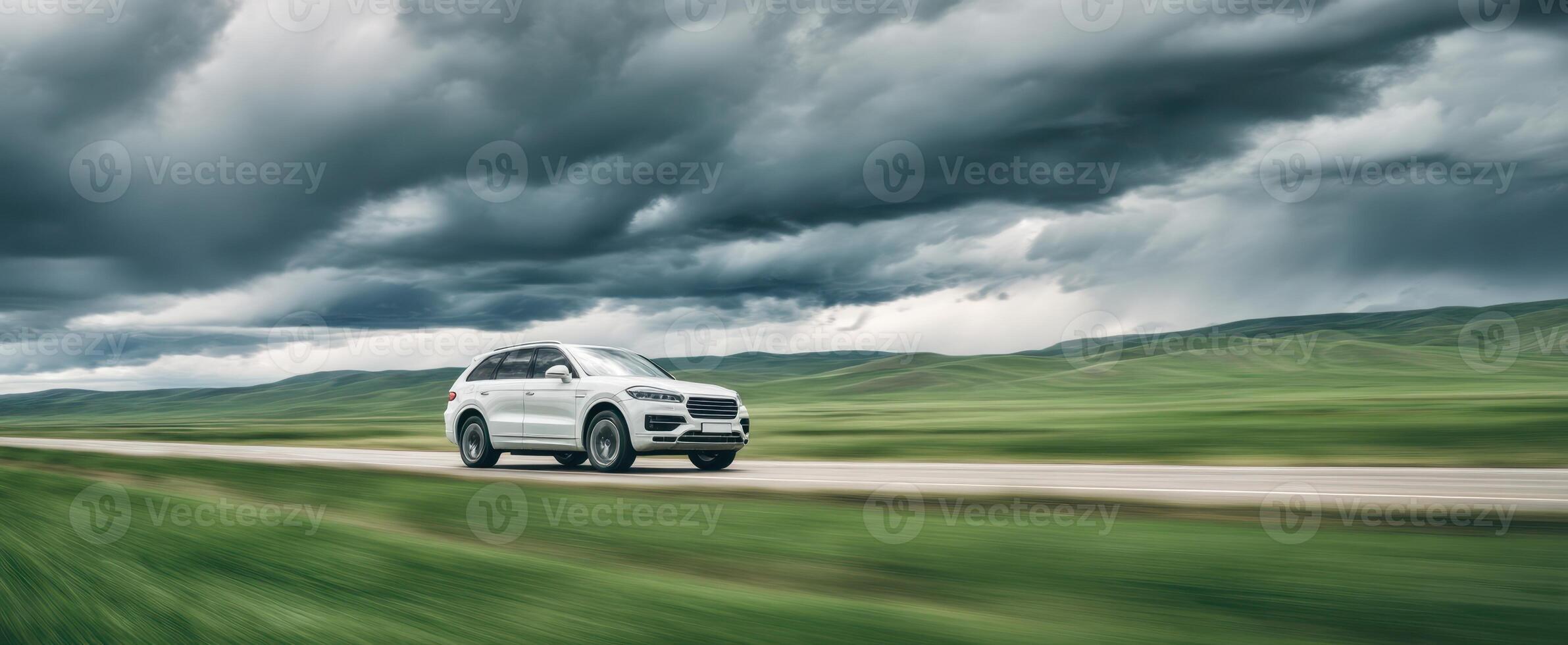 The sleek SUV cruising along a picturesque road under dramatic clouds. photo