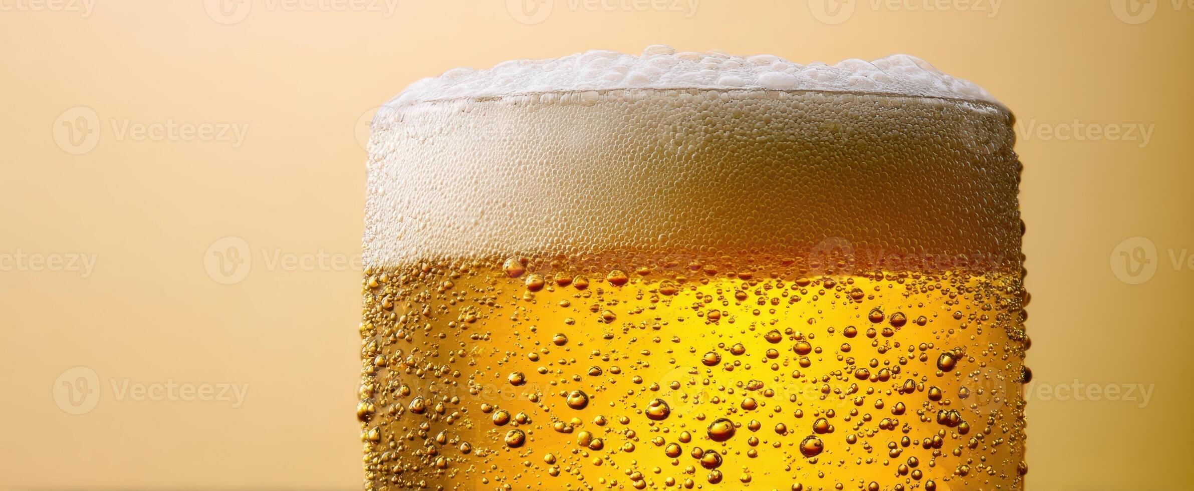 The frothy glass of golden beer with refreshing bubbles. photo