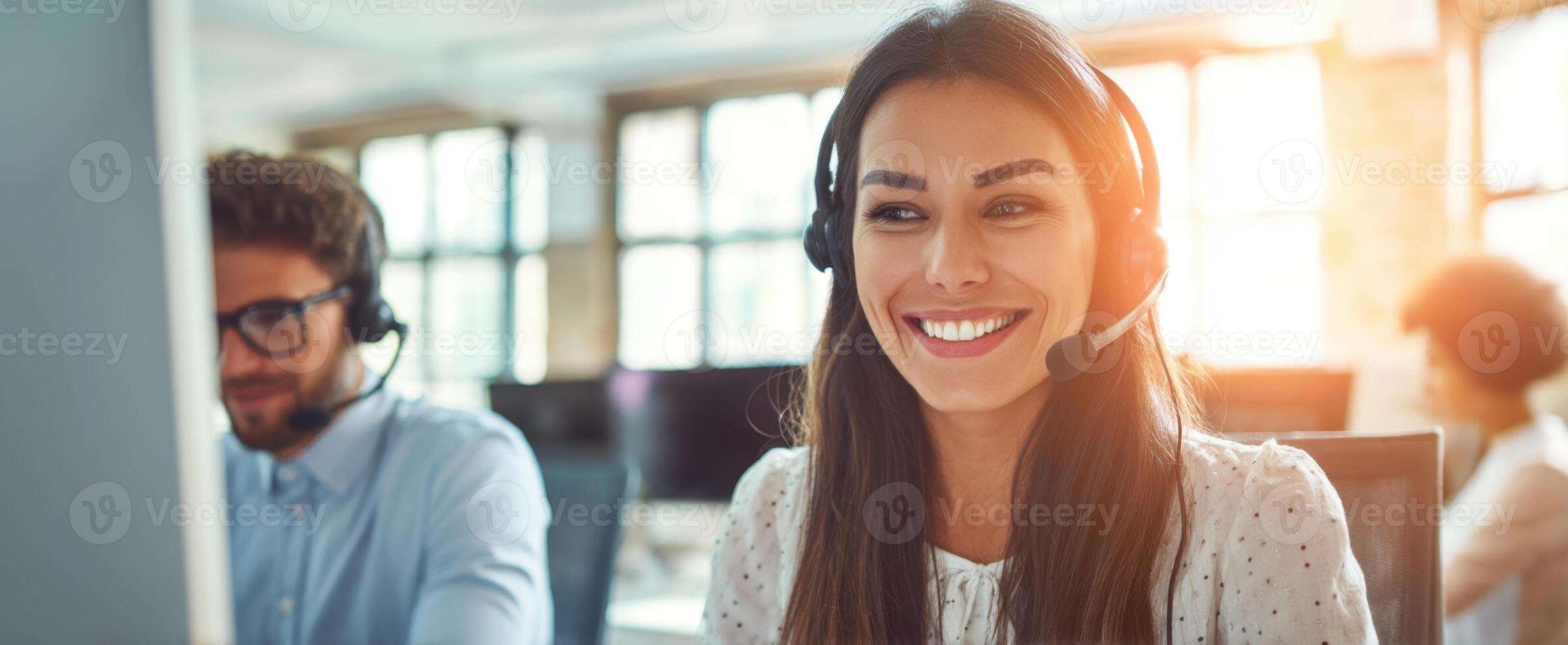 The smiling woman in a headset working in a collaborative office environment. photo