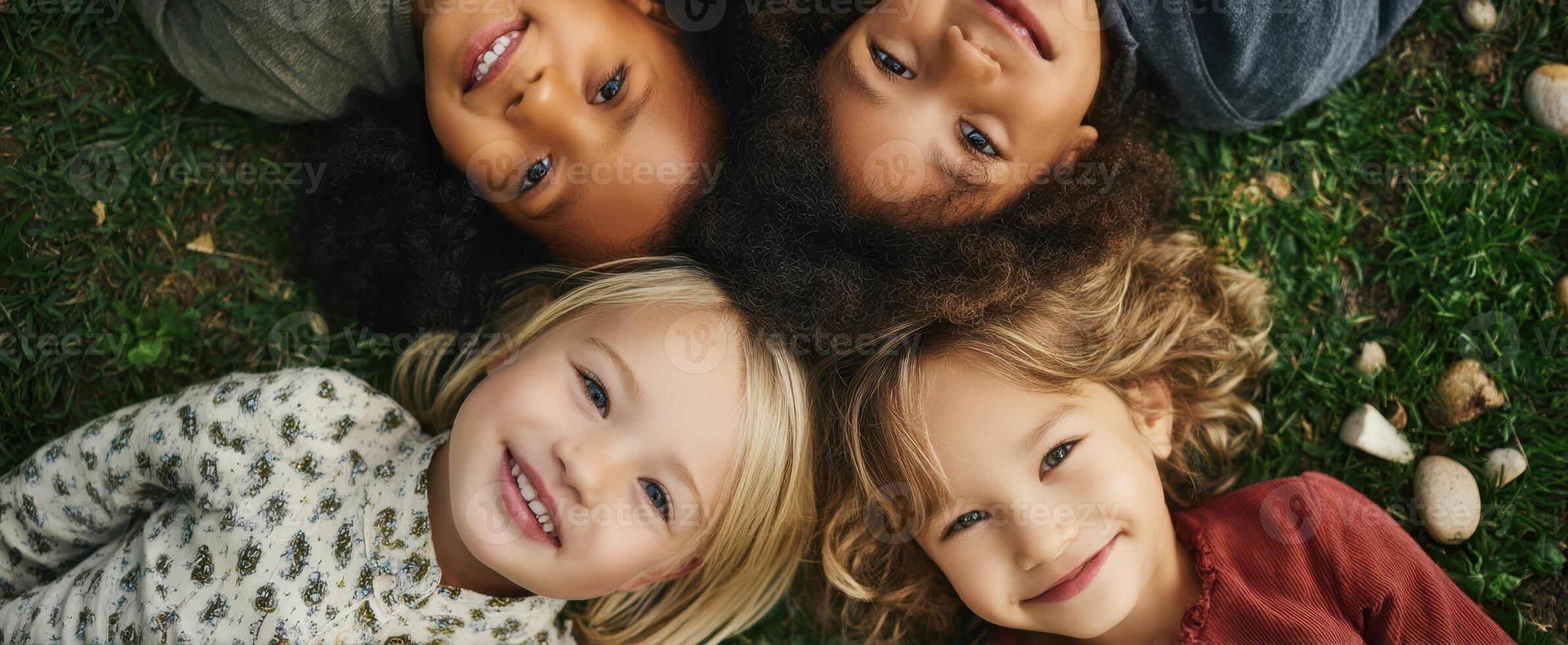 The joyful children lying together on grass sharing smiles and laughter. photo