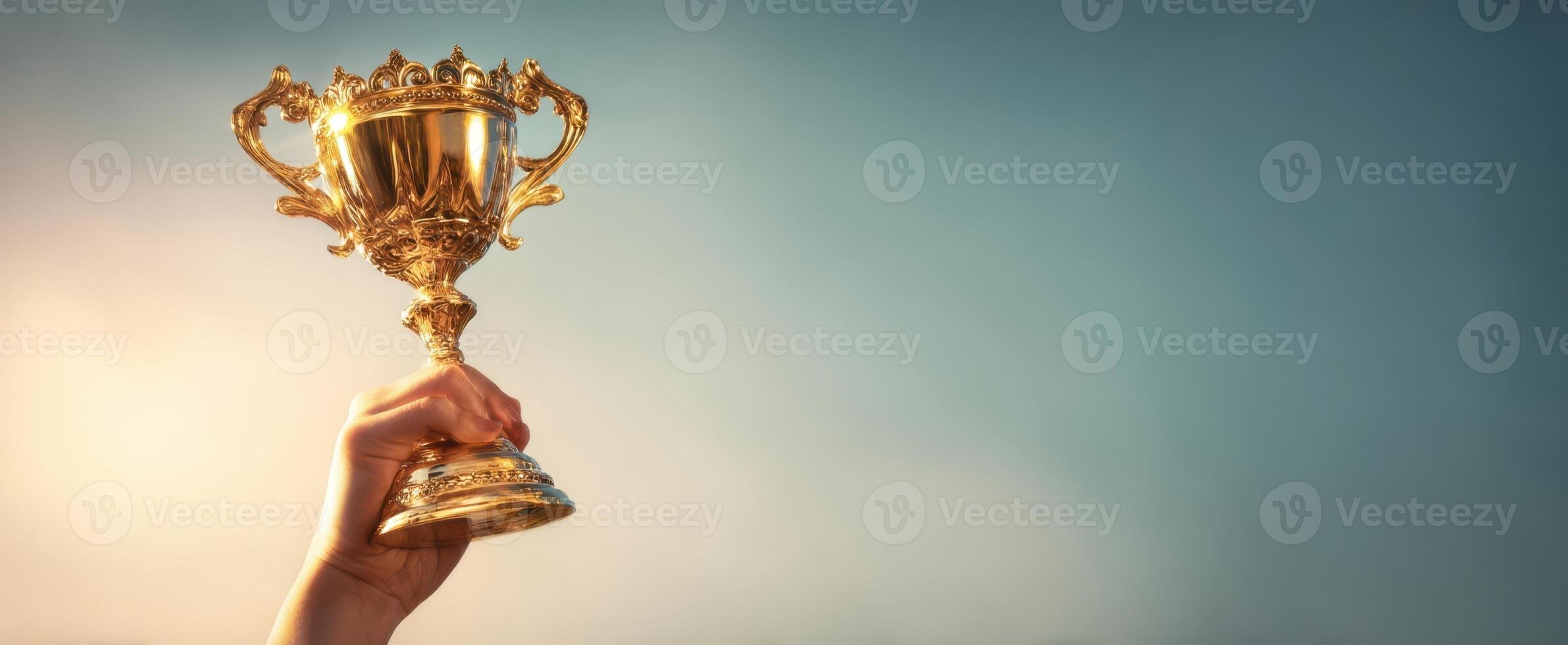 The trophy held high symbolizing victory and achievement against a beautiful backdrop. photo