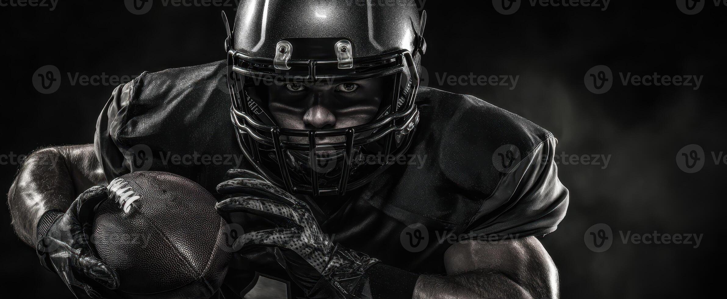 The powerful football player in a dramatic black and intense action pose. photo