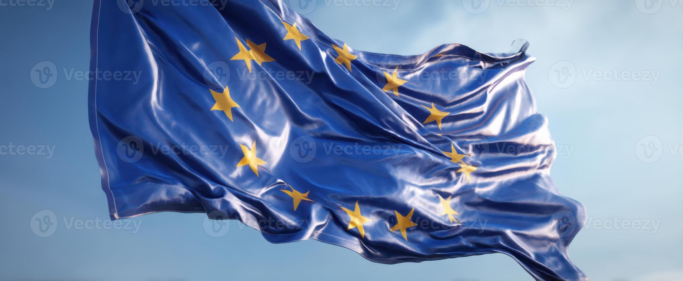 The European Union flag waving gracefully in a clear blue sky photo