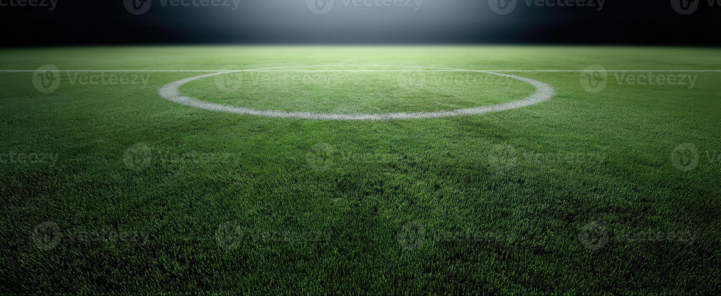 The illuminated soccer field under spotlights with detailed turf and central circle photo