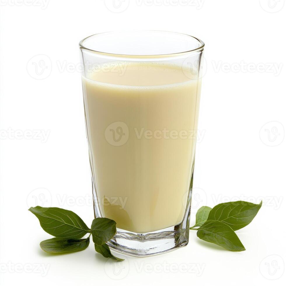 A glass of milk with leaves on a white background photo