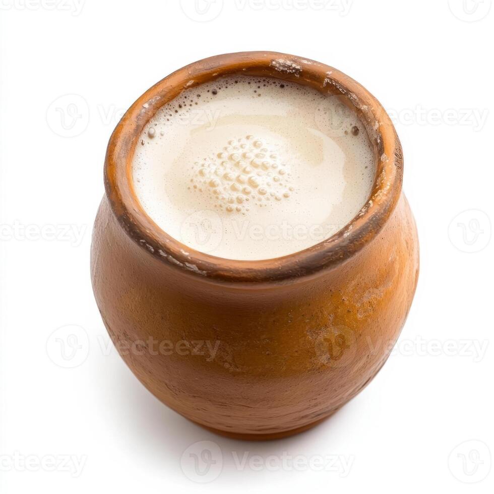A brown clay pot with milk and a spoon photo