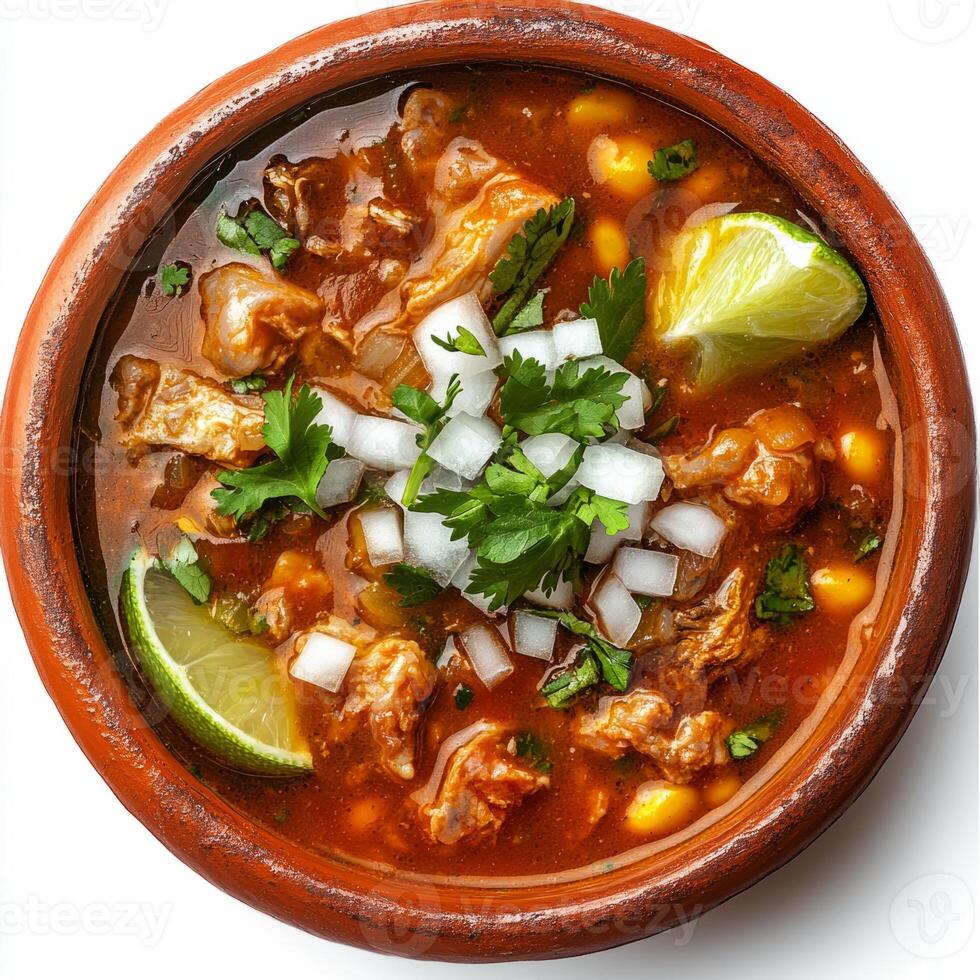 Chicken and corn soup in a brown bowl with lime slices photo