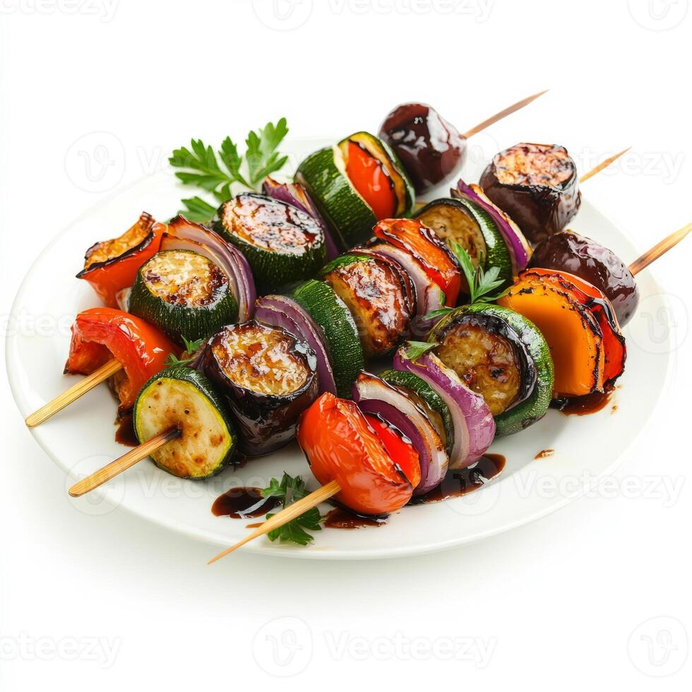 A plate of roasted vegetable skewers with zucchini, eggplant, bell peppers, and onions, drizzled with balsamic glaze, isolated on clean white background. photo