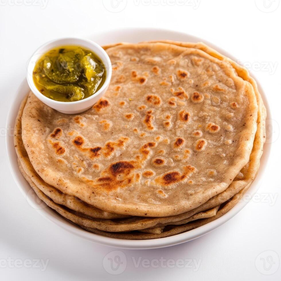 A close-up of a flaky paratha, with layers of whole wheat dough and a golden brown color, served with a side of pickle, isolated on clean white background. photo
