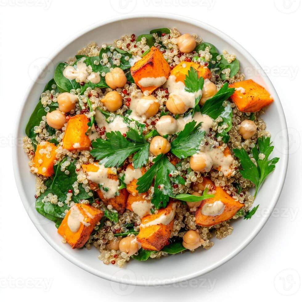 A colorful quinoa salad with roasted sweet potatoes, chickpeas, spinach, and a lemon-tahini dressing, garnished with fresh parsley, isolated on clean white background. photo
