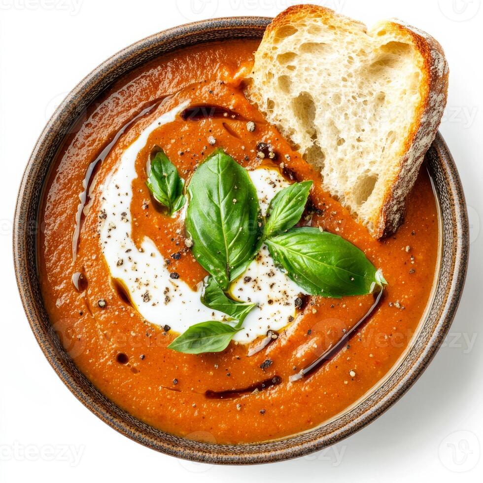 A bowl of creamy tomato and basil soup, with roasted tomatoes, onions, garlic, vegetable broth, and a touch of balsamic vinegar, blended until smooth and creamy, topped with a swirl of coconut cream, photo